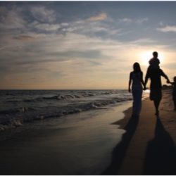 Young family On Beach In Sunset